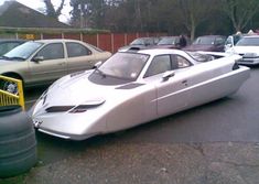 a silver sports car parked in a parking lot next to other cars