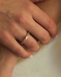 a woman's hand with a wedding ring on her left wrist and two diamonds in the middle