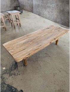 a wooden bench sitting on top of a cement floor