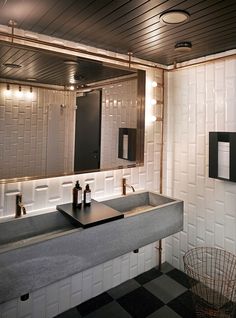 a bathroom with a sink, mirror and lights on the wall above it's counter