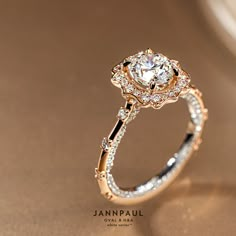 a diamond ring is shown on top of a gold surface with the words janpaul written below it