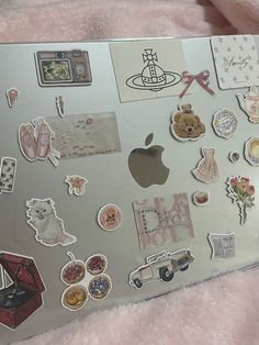 an apple laptop covered in lots of stickers