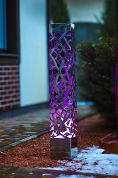 a tall purple vase sitting on top of a sidewalk