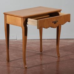 a small wooden desk with drawers on one side and an open drawer on the other