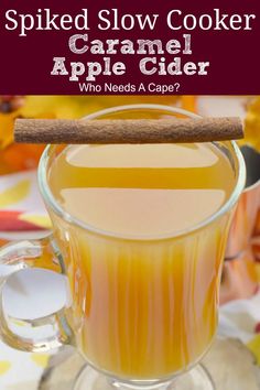 a glass mug filled with apple cider and cinnamon stick