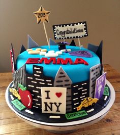 a birthday cake decorated with an image of the new york city skyline and nameplates