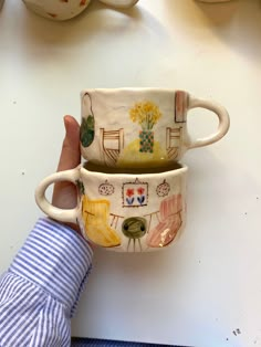 two coffee mugs sitting next to each other on top of a white countertop