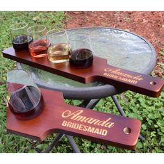 three glasses of wine are sitting on a table with two wooden paddles that read, amanda bridesmaid