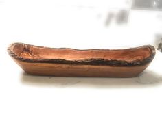 a wooden bowl sitting on top of a white counter