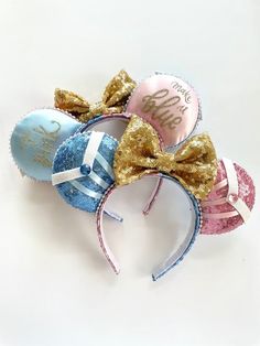 three hair bows with gold and blue sequins are on top of each other