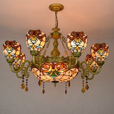 a stained glass chandelier with five lights hanging from it's center point