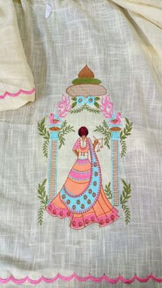 an embroidered piece of cloth with a woman in a dress and hat on the front