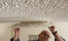 an older man is fixing the ceiling in his home