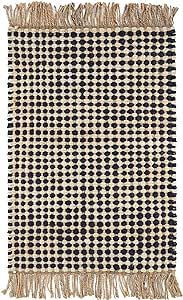 a black and white checkered rug with fringes on the bottom, in front of a