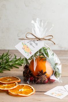 an orange sitting on top of a wooden table next to slices of fruit and spices