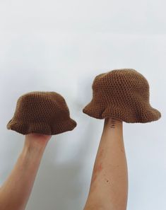 someone is holding their hands up to show the brown knitted clochet hat