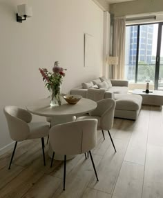 a living room filled with furniture and a white table topped with a bowl of flowers