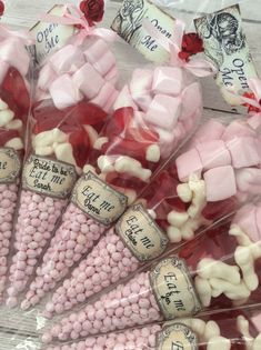 candy sticks with pink and white candies in cellophane bags on a wooden table