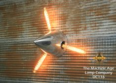 the machine age lamp company logo is shown in front of a corrugated wall with light coming from it