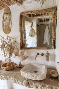 a bathroom with a sink, mirror and plants on the counter in front of it