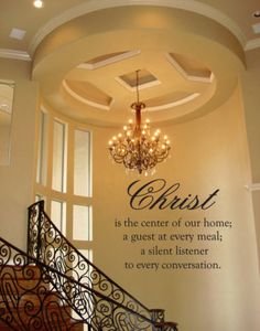 a chandelier hanging from the ceiling in front of a wall that says, bess this home and all who enter