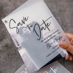 a person holding up a save the date card