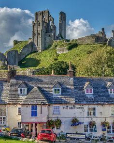 the castle hotel is situated on top of a hill with cars parked in front of it