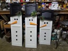 three snowmen made out of shutters in a shop