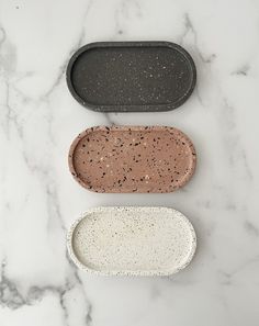 three oval trays sitting on top of a marble counter