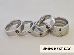 four silver rings with sun and moon designs on them, sitting next to each other