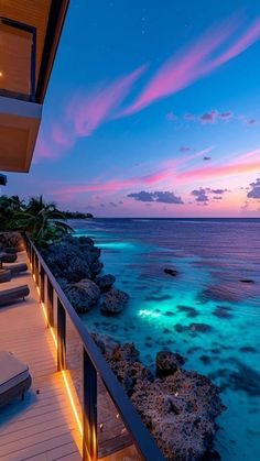 an ocean view from the balcony of a house at night with bright lights on the water