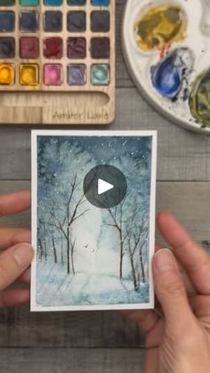 someone is holding up a card with a painting on it and the video has been altered