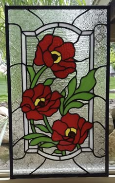 a stained glass window with red flowers on it