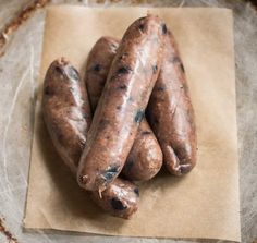 three hotdogs sitting on top of a piece of wax paper