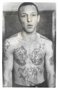 an old photo of a man with tattoos on his chest