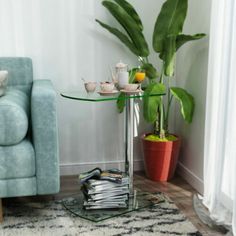 a living room with a couch, chair and coffee table on the floor in front of a potted plant