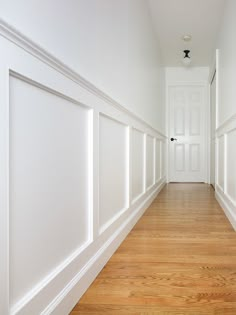 an empty hallway with white walls and wood floors, the words wall molding on it