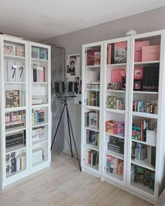 a room with white bookcases filled with books