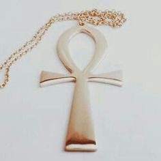 an egyptian cross necklace on a white background