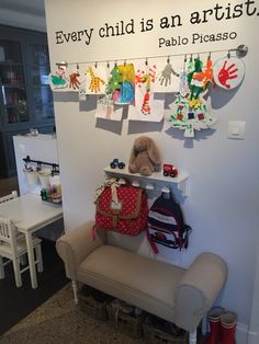 a child's artwork display in the corner of a room