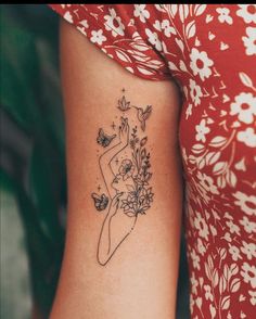 a woman's arm with a tattoo on it and flowers in the back ground