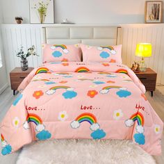 a pink bed with rainbows, clouds and love written on the comforter set