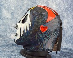 a helmet with an orange and white heart on the side is sitting on a black stand