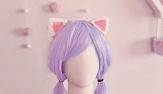 a wig with long purple hair and cat ears on it's head next to a pink wall