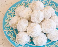 a blue plate topped with snowball cookies on top of a white and blue table