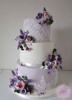 three tiered wedding cake with purple flowers and lace