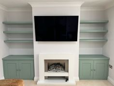 a flat screen tv mounted to the side of a wall in a living room with built - in shelving