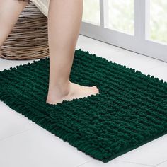 a person standing on top of a green rug in front of a white floor and window