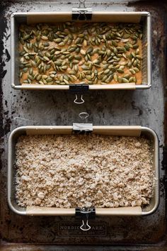 two pans filled with food sitting on top of a counter next to each other