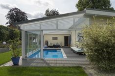 a house with a swimming pool in the middle of it's yard and covered patio area